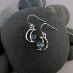 Handcrafted silver crescent moon dangle earrings with rainbow moonstones by Mikel Grant Jewellery.