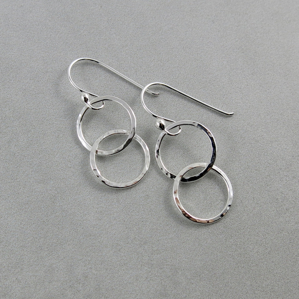 Sterling silver embrace earrings by Mikel Grant Jewellery. Hammer textured interlocking silver ring earrings.