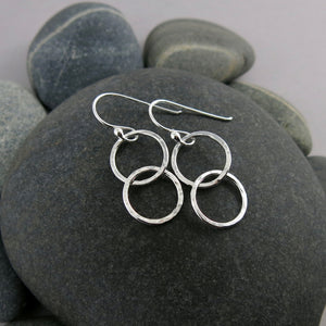 Sterling silver embrace earrings by Mikel Grant Jewellery. Hammer textured interlocking silver ring earrings.