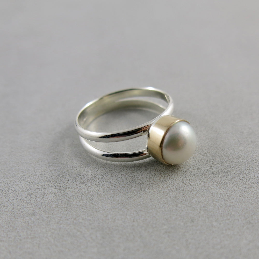 Silver and Gold Split Shank Pearl Ring by Mikel Grant Jewellery. White freshwater button pearl bezel set in 14K gold on a sterling silver split shank band.