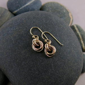 Solid gold mixed metal love knot earrings by Mikel Grant Jewellery. Artisan made infinite knot earrings in 14K yellow, rose and palladium white gold.