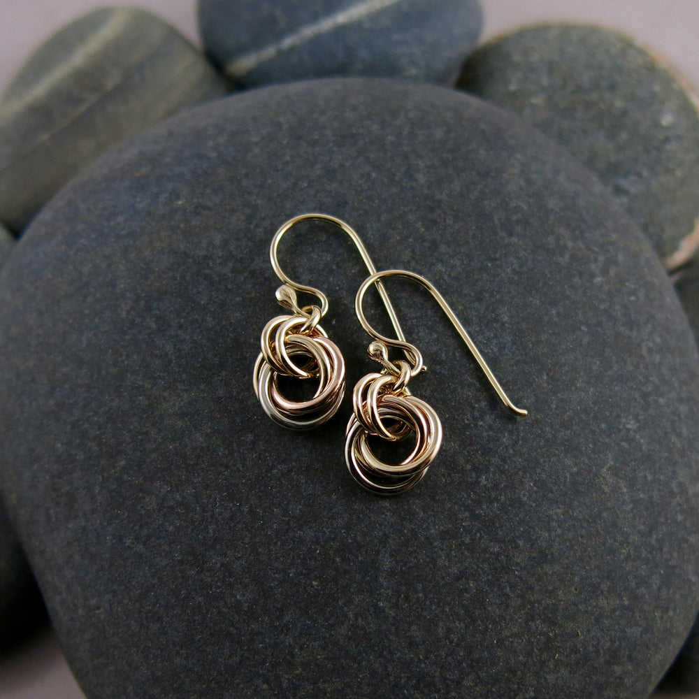 Solid gold mixed metal love knot earrings by Mikel Grant Jewellery. Artisan made infinite knot earrings in 14K yellow, rose and palladium white gold.