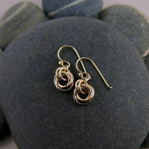 Solid gold mixed metal love knot earrings by Mikel Grant Jewellery. Artisan made infinite knot earrings in 14K yellow, rose and palladium white gold.