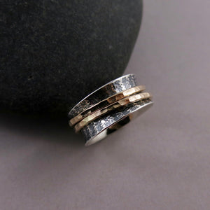 Sterling silver meditation ring with oxidized striped pattern and two hammer textured 14K gold filled spinning bands.  By Mikel Grant Jewellery.